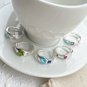 Detailed macro of 925 silver open ring set with colorful gemstone charms and engravings