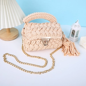 Sac bandoulière en crochet fait main avec chaîne dorée et détails de pompons chics.