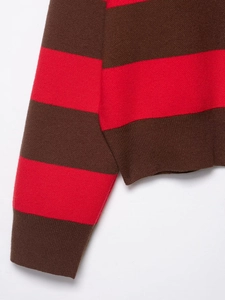 Detailed close-up of ribbed cuffs and stitching on a striped knit sweater