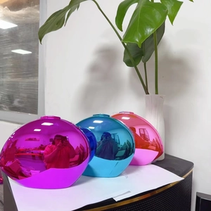 Three metallic egg-shaped crossbody bags in purple, sky blue, and pink with mirror finish