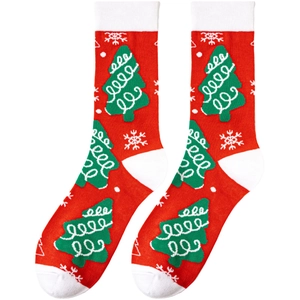 Detail of knit Christmas socks featuring green Christmas trees and white snowflake patterns