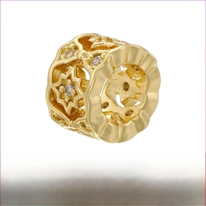 Detailed macro of gold brass honeycomb spacer bead with star hollows and zircons