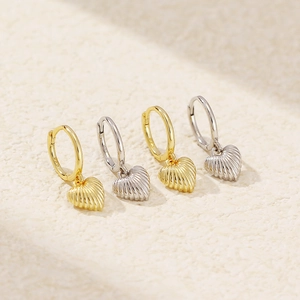 Detailed close-up of S925 sterling silver heart earrings in gold and silver finishes