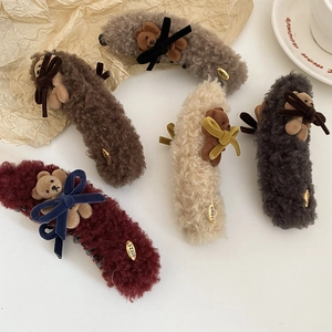 Detailed view of five plush teddy bear hair claws in burgundy, brown, beige, and grey