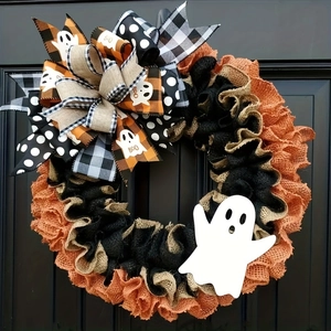 Halloween ghost door wreath with burlap bows and orange mesh on a black front door