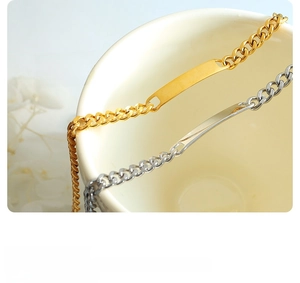 Detail of gold and silver cuban link bracelets with square metal plate on ceramic cup