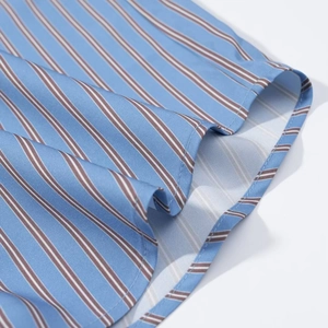 Close-up of blue striped cotton shirt featuring precise hem stitching and fabric texture