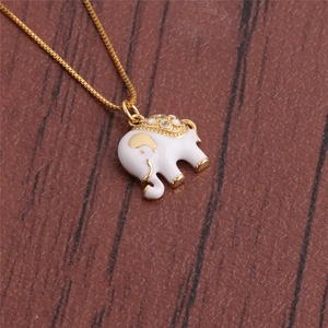 Detailed view of a gold-plated elephant pendant with white enamel and sparkling rhinestones