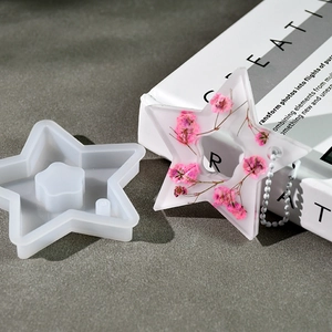 Star-shaped silicone mold shown with a finished resin piece containing pink dried flowers