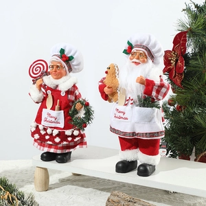 Standing Santa and Mrs. Claus chef dolls on a white bench with a Christmas tree background