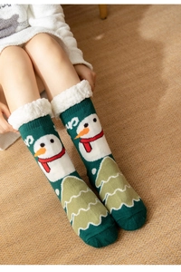 Gros plan de chaussettes d'hiver vertes avec motifs bonhomme de neige et revers polaire