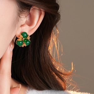 Boucles d'oreilles vintage fleurs vertes en triangle sur modèle pour un style rétro chic