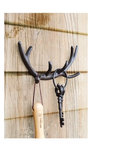 Detailtextur rustikaler Wandhaken aus Eisen in Geweihform auf einer natürlichen Holzwand