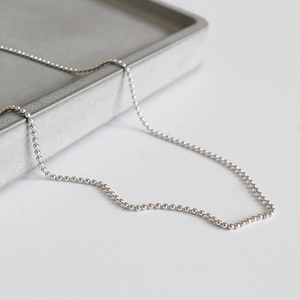Minimalist S925 sterling silver bead chain necklace for women on a gray minimalist tray