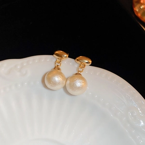 Detailed macro shot of vintage gold earrings with matte cotton imitation pearl finish