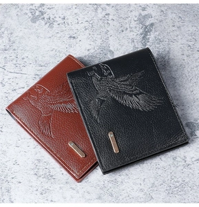 Detail of embossed eagle pattern and metal logo on men's leather bifold wallets