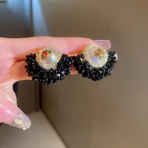 Vintage fan-shaped floral stud earrings with black beads and a white pearl center