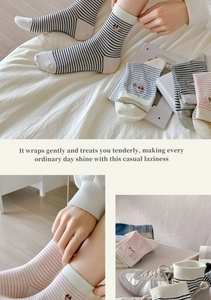 Close-up of fine striped cotton socks featuring delicate dachshund puppy embroidery detail