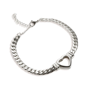 Detail of silver Cuban link bracelet featuring a hollow heart charm and lobster clasp