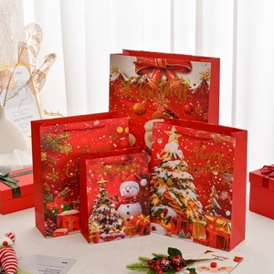 Set of four red Christmas paper gift bags with Santa and Snowman holiday illustrations