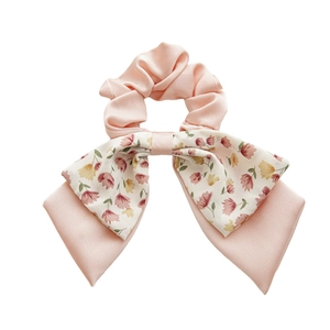 Floral double-layered bow hair scrunchie in pink and beige with a soft fabric texture