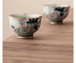 Détail de fleurs de magnolia peintes à la main et texture craquelée des tasses en céramique