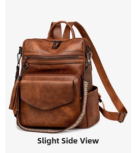 Detail view of brown vintage backpack featuring leather texture and decorative tassel