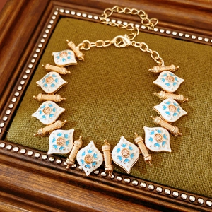 Detail of vintage gold bracelet with blue floral enamel links and champagne crystals