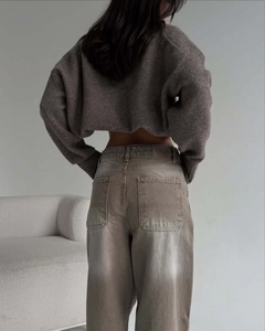 Détail de la taille du jean gris-brun avec écusson en cuir sur la vue arrière d'un mannequin