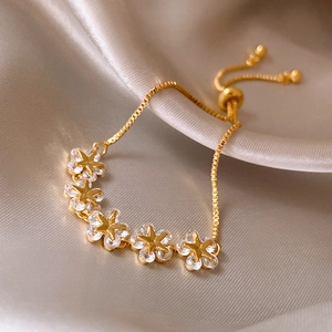 Detailed macro view of gold-plated flower bracelet with sparkling cubic zirconia