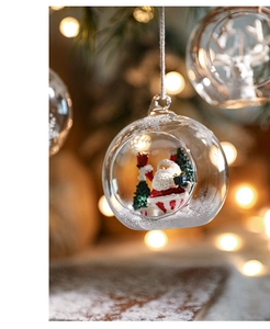 Detail of a Christmas glass ball with Santa Claus and a tree hanging on a festive tree