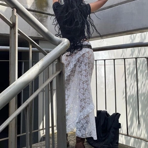 Detail of white lace maxi skirt showing transparent texture and back view on stairs