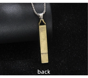 Macro shot of the back of a vintage gold-tone functional whistle necklace on dark leather