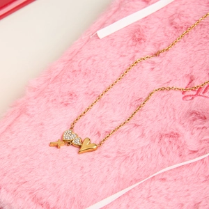 Detail of 18K gold heart and cross pendants with crystal inlays on a fine chain necklace