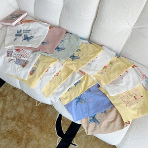Detail von bunten Canvas-Beuteln mit Schmetterlings- und Cartoon-Druck in Pastellfarben
