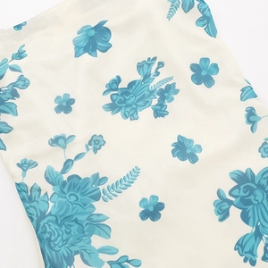 Primer plano del estampado floral azul en tejido texturizado crema del vestido de verano