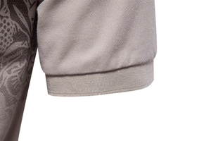 Close-up of the grey piqué fabric texture and ribbed cuff detail on a men's polo shirt