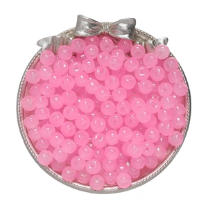 Close-up of pink 8x7mm apple-shaped glass beads in a silver bow decorated container
