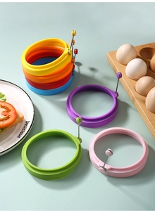 Close-up of colorful silicone egg rings with metal handles in various bright shades