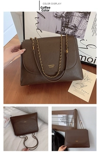 Detail of dark brown leather chain bag with gold hardware and brand logo lettering