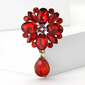 Vintage gold-tone brooch with elegant red rhinestones and crystal drop pendant
