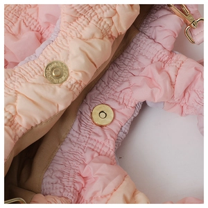 Detail of pink gradient pleated fabric with gold magnetic snap closure and D-ring hardware