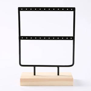 Double-layer black metal earring organizer rack with a natural wooden base for jewelry