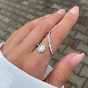 Detail of silver open ring with oval clear stone and micro-pave band on middle finger