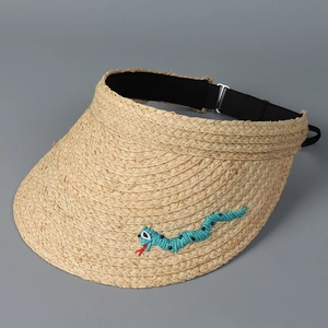 Detail der Raffia-Sonnenhut mit grüner Schlangenstickerei und gewebter Strohstruktur