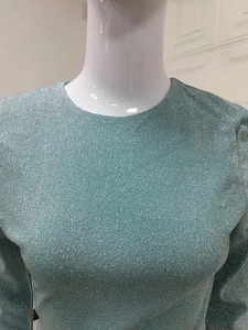 Close-up of teal glitter fabric with silver sparkles on a crew neck bodycon dress