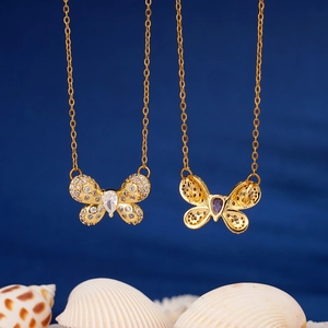 Elegant gold butterfly pendant necklace with zircon rhinestones on deep blue backdrop