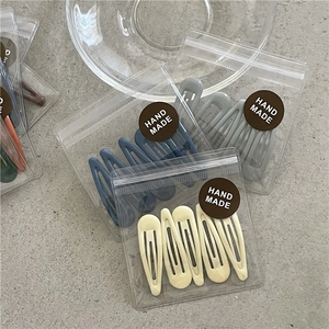 Macro detail of multi-colored matte drip oil hair clips in handmade craft packaging
