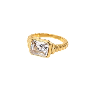 Gold croissant twist ring featuring a rectangular clear zircon stone on white backdrop