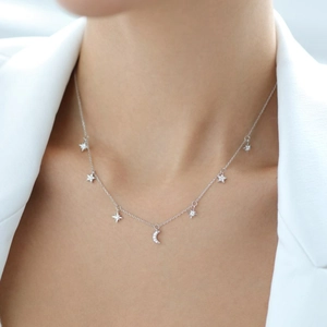 Detail shot of a silver S925 star and moon necklace with sparkling zircon on a model